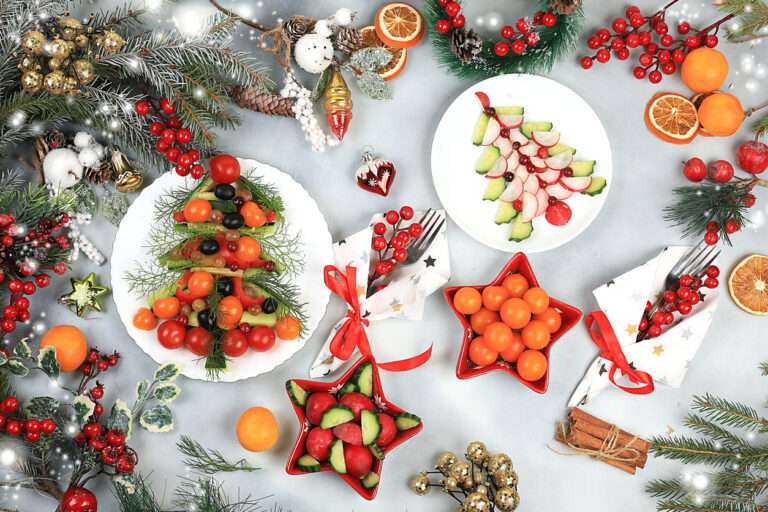 Christmas New Year dishes, traditional festive salad with edible vegetarian Christmas trees made of vegetables and fruits, food design idea, fir branches and decorations