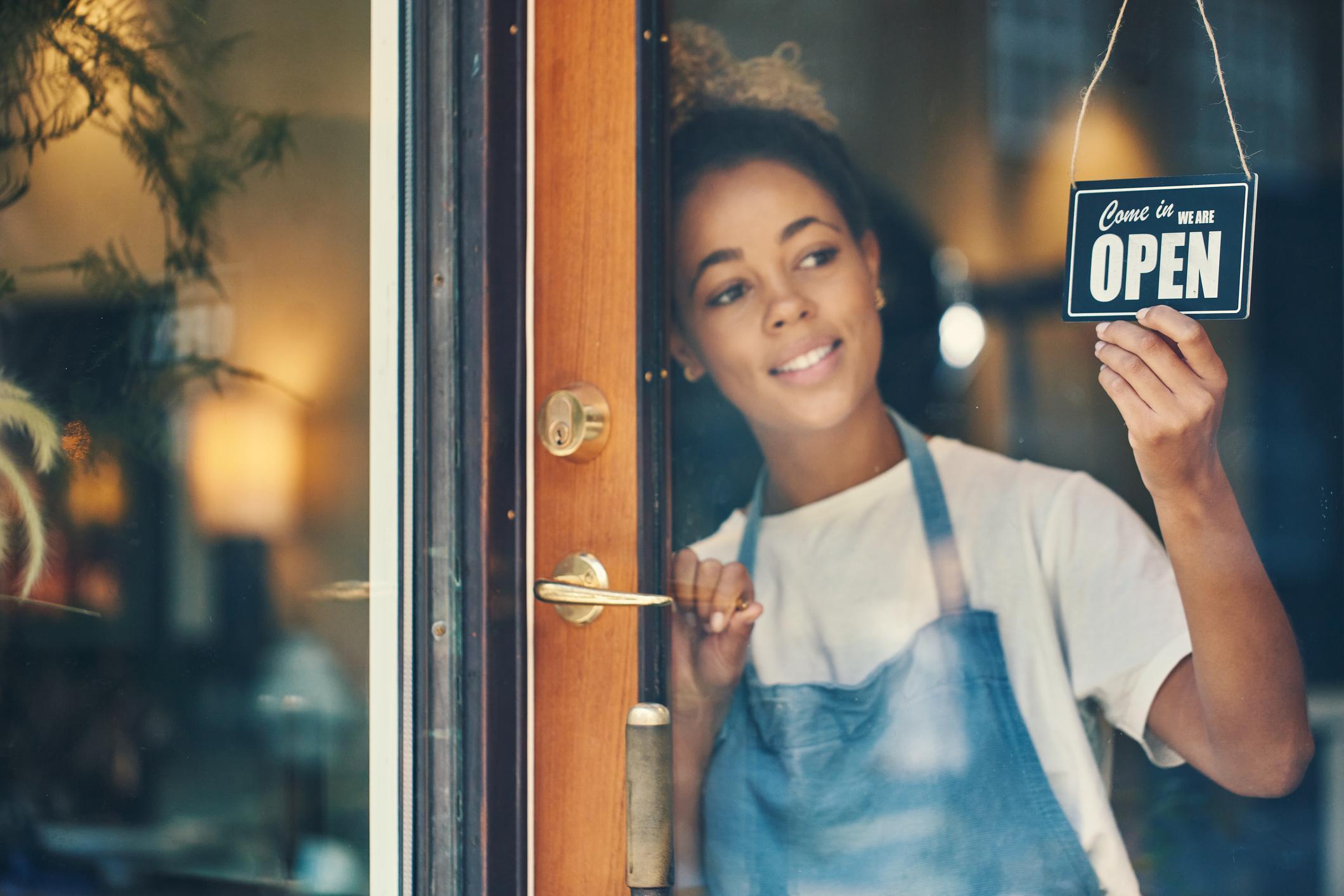 Woman turning an open sign for her business