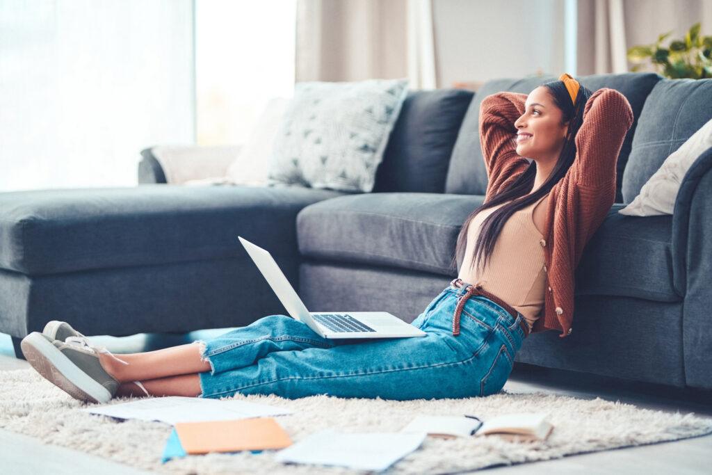 young woman relaxing while working in the living room at home