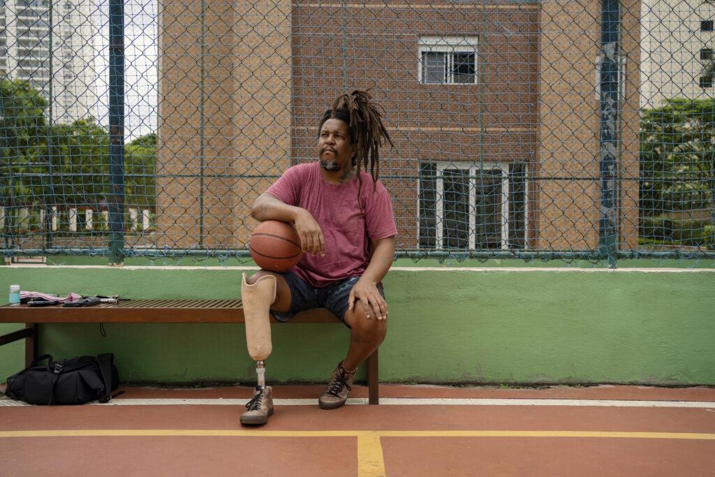 Man playing basketball with prosthetic leg. 