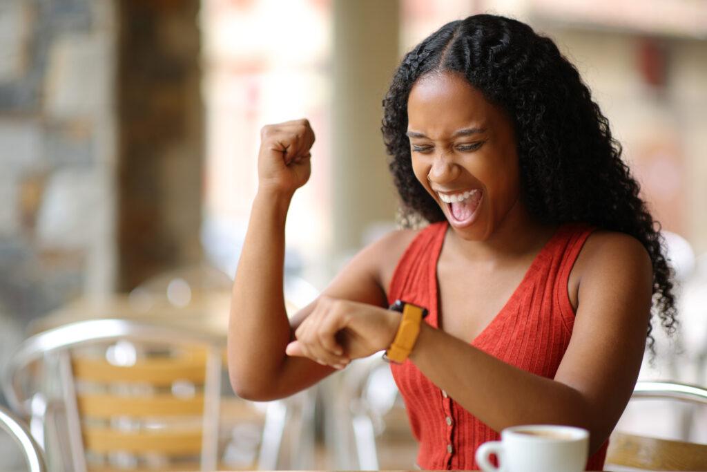 Excited woman looking at smart watch
