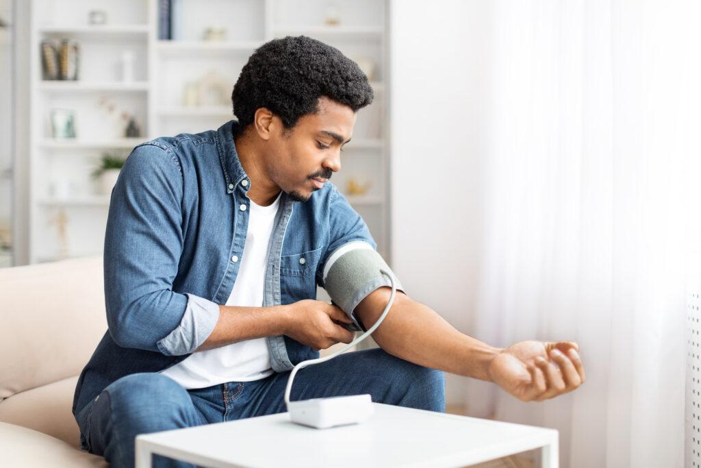 Young Man Checking His Blood Pressure at Home 