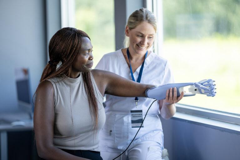 Woman with prosthetic arm and doctor