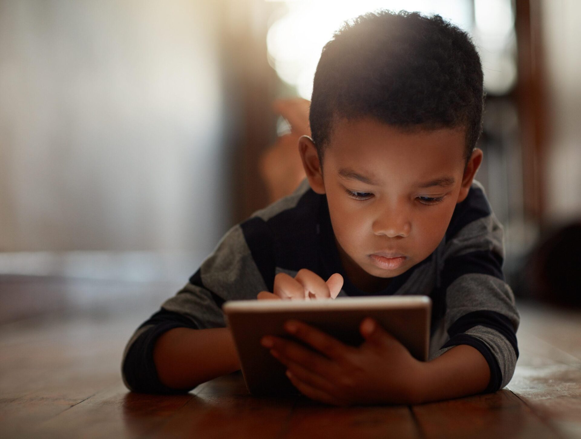 Child using a tablet on the floor